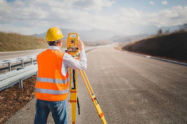Ontario land surveyor operating a total station on a construction site